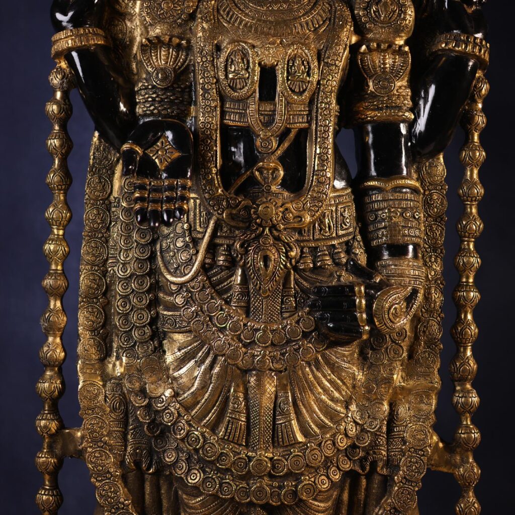 Mid-body view of the large brass Tirupati Balaji statue with golden ornaments.
