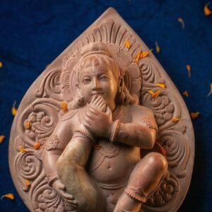 close up pink stone bal krishna statue carving detail