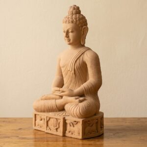 Handcrafted sandstone Buddha idol seated in a meditative pose on a decorative base.