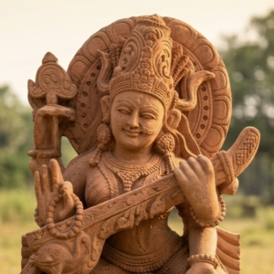 Handcrafted sandstone Saraswati idol, intricately detailed, showcasing the goddess with a veena, in warm earthy tones.