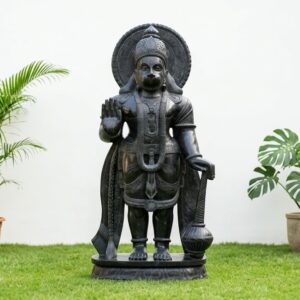 Front view of a large black stone statue, featuring a standing Hanuman idol.