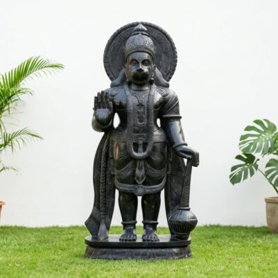 Front view of a large black stone statue, featuring a standing Hanuman idol.