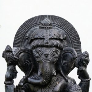 Intricate detailing on the headdress enhances the 17 Inch Black Stone Sitting Ganesh Idol.